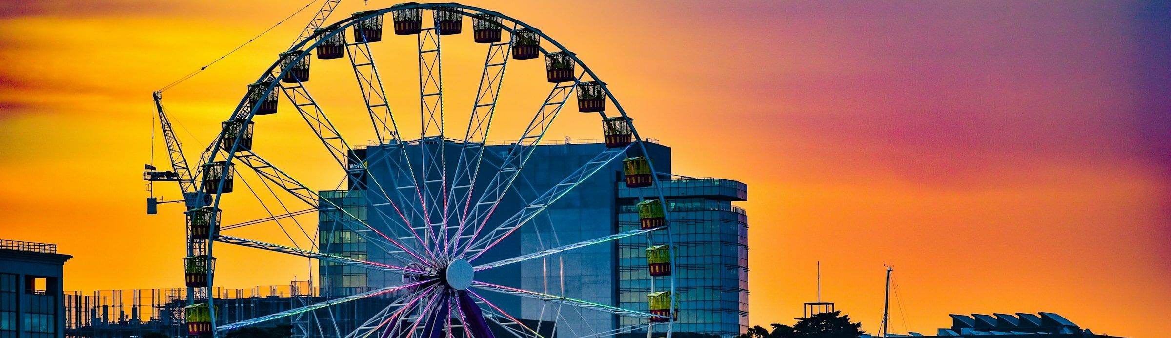 The ferris wheel on Geelong's waterfront lit against an orange sunset