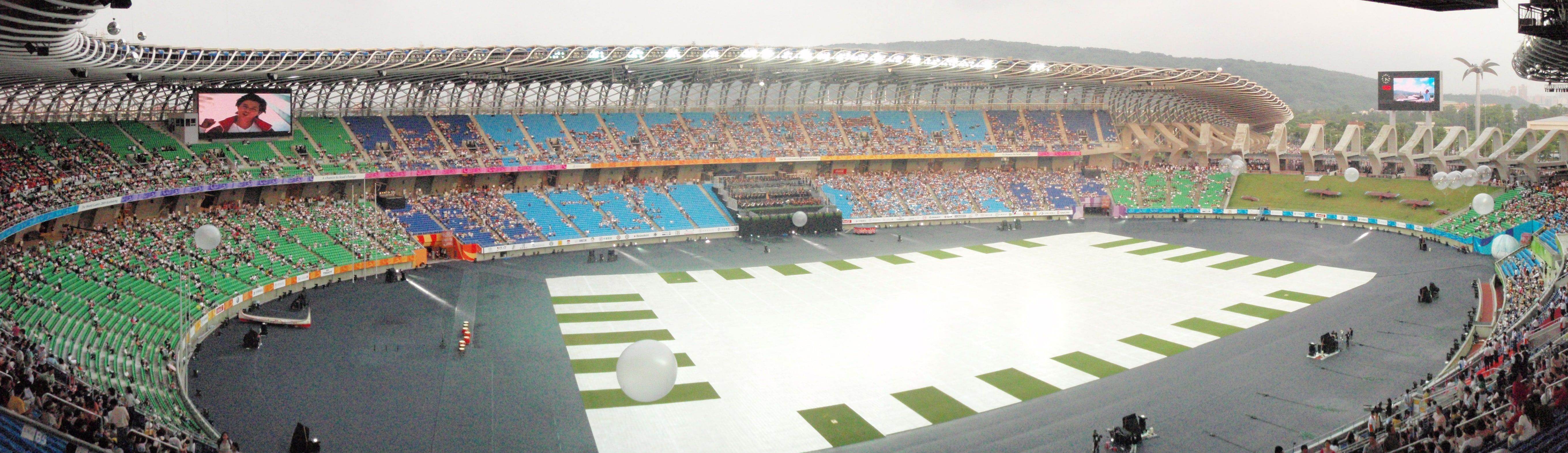 Kaohsiung National Stadium from the stands, its spiral steel roof curving around a full crowd